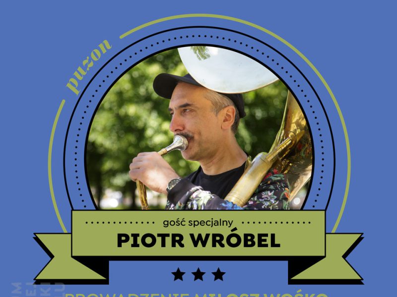 Grafika zapraszająca na Małą Akademię Instrumentów Jazz z udziałem Piotra Wróbla. Na jasno foletowym tle białej i czarne napisy, w centralnej części grafiki fragment kolorowego zdjęcia artysty z puzonem. Treść grafiki taka jak w artykule