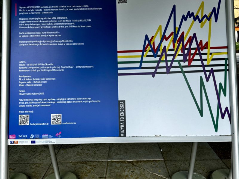 Tablica informacyjna wystawy „Music Non Stop”, z lewej strony tekst po polsku o wpływie muzyki na emocje i rozwój człowieka, a po prawej kolorowy wykres fal przypominający linie dźwięku